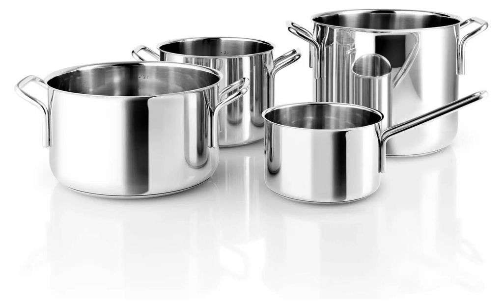 A set of four stainless steel pots and pans arranged on a white surface.