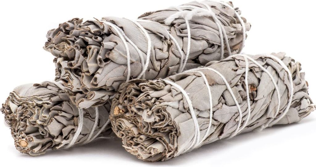 Three bundles of dried white sage tied with white string, presented on a white background.