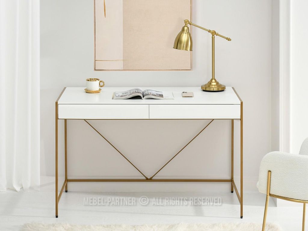 A white desk with gold accents, a lamp, a book, and a mug.