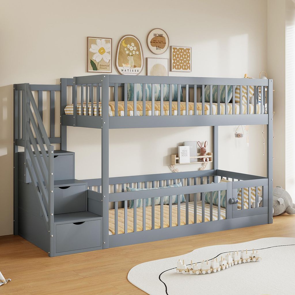 A gray wooden bunk bed with stairs and drawers, set up in a child's bedroom with wall art and decorations.