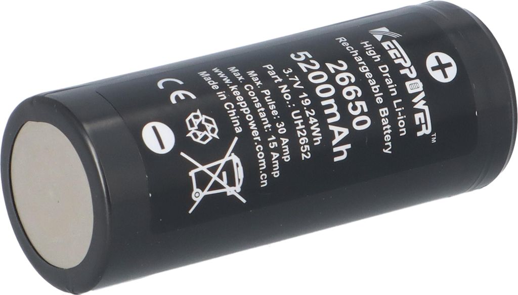 A black cylindrical battery with white text and symbols printed on it, set against a white background.