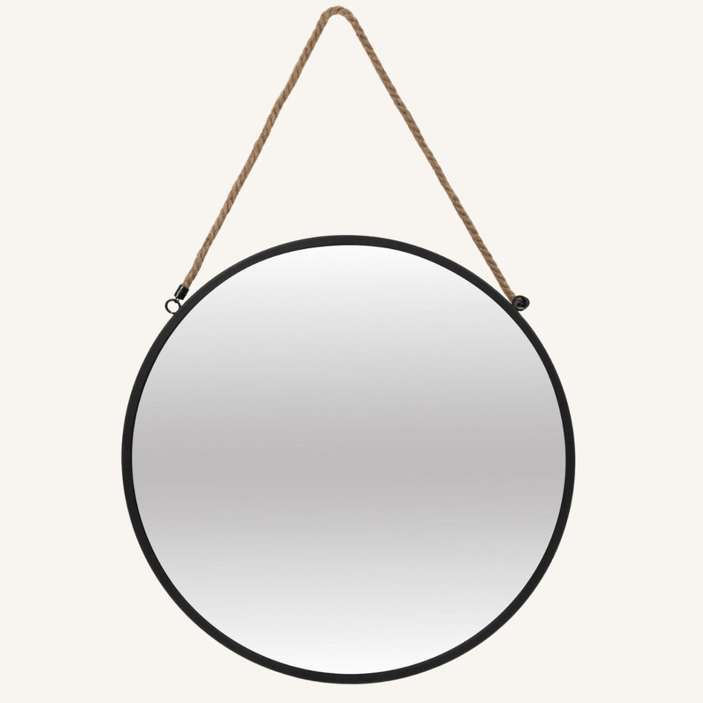 A round mirror with a rope hanger against a light gray background.