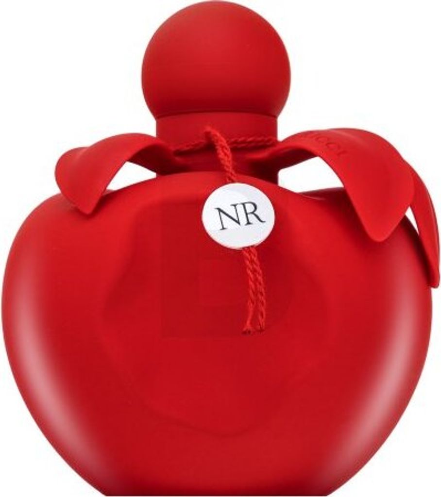 A red perfume bottle with a round cap and petal-like accents around the neck. A small white tag with 'NR' printed on it hangs from the neck with a string.