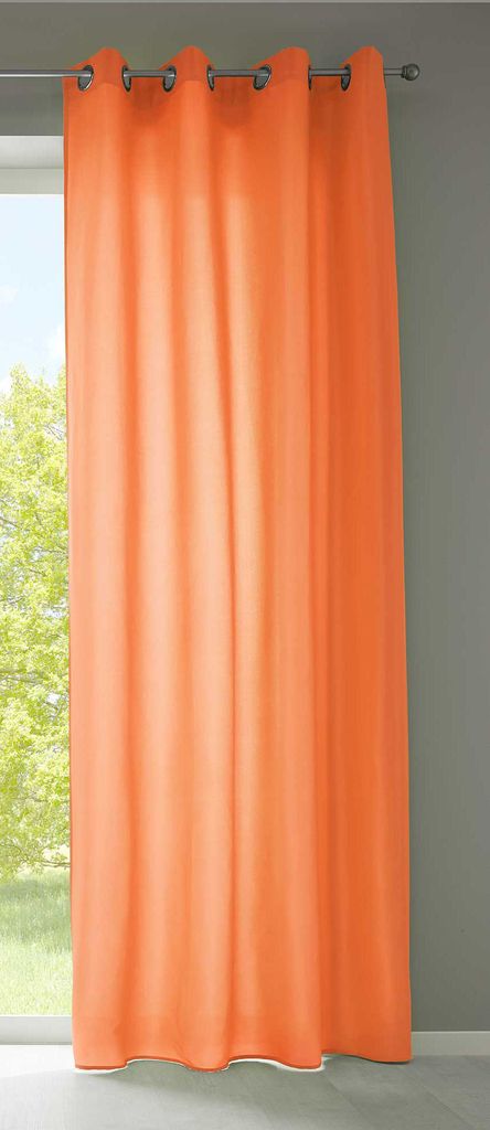 A single orange curtain hanging in front of a window.