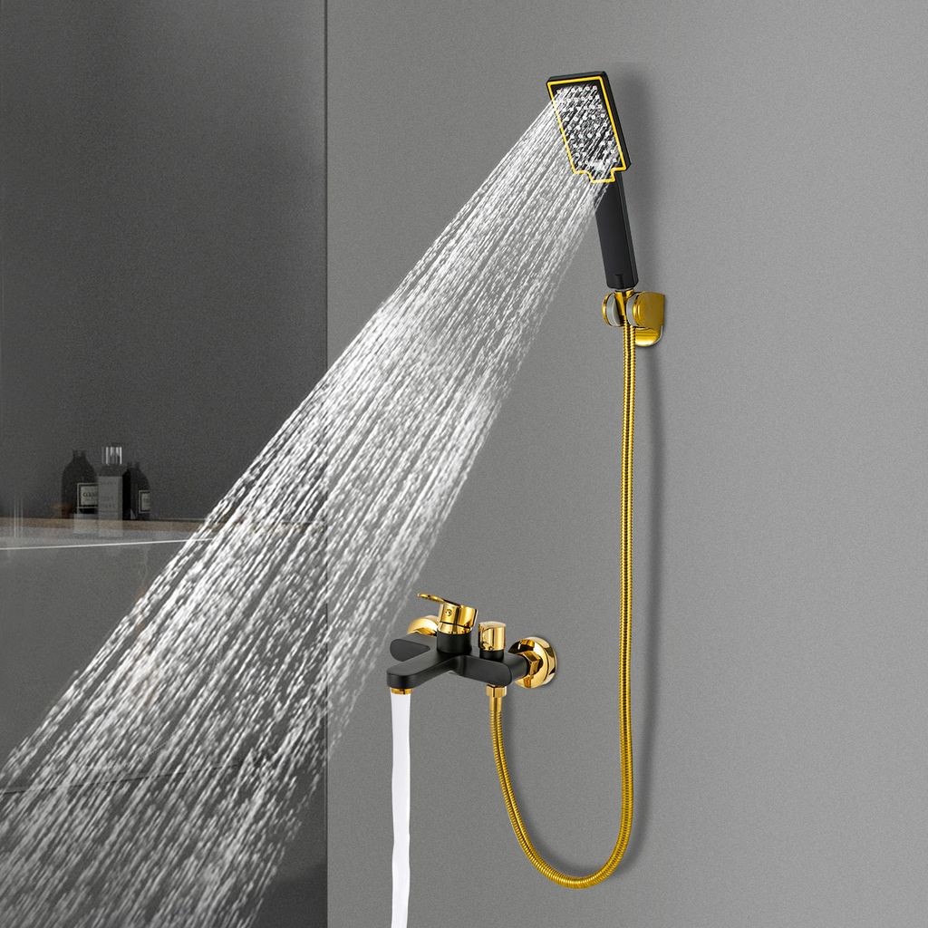 A black and gold shower faucet and hand shower head with water spraying from the shower head.
