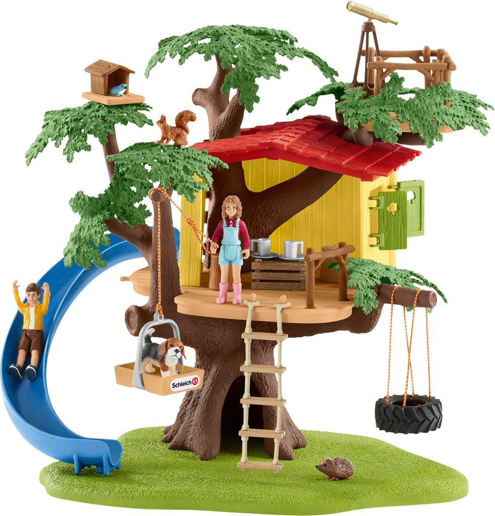 A toy treehouse with figures and accessories, set on a green base.