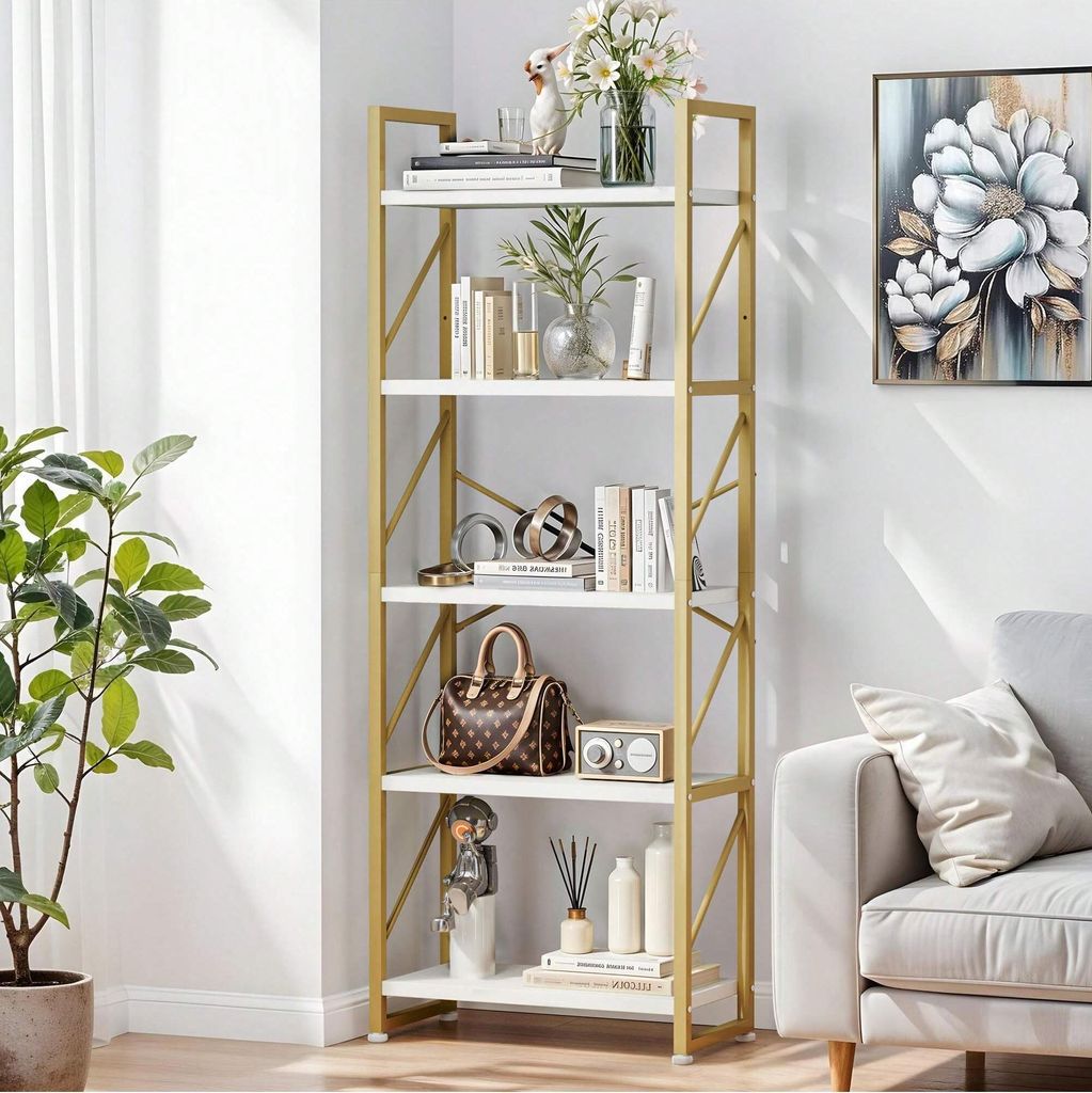 A white and gold bookshelf filled with decorative items and books, placed in a room next to a sofa and a plant.