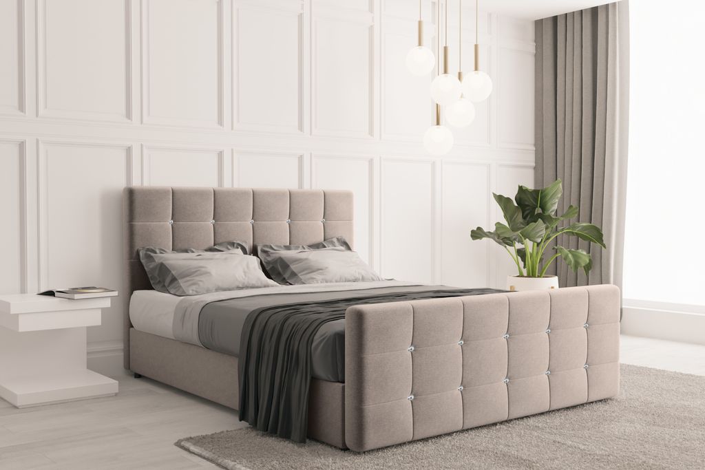 A bedroom scene featuring a bed with a headboard and footboard, complete with bedding and a throw blanket. A bedside table with a book and a potted plant are also visible.