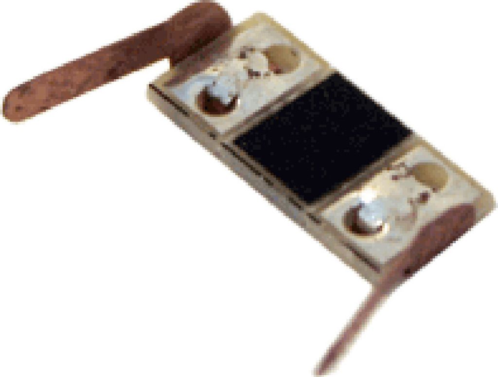 A close-up shot of a model train part, likely a current collector or wheel wiper, with two copper-colored leads.