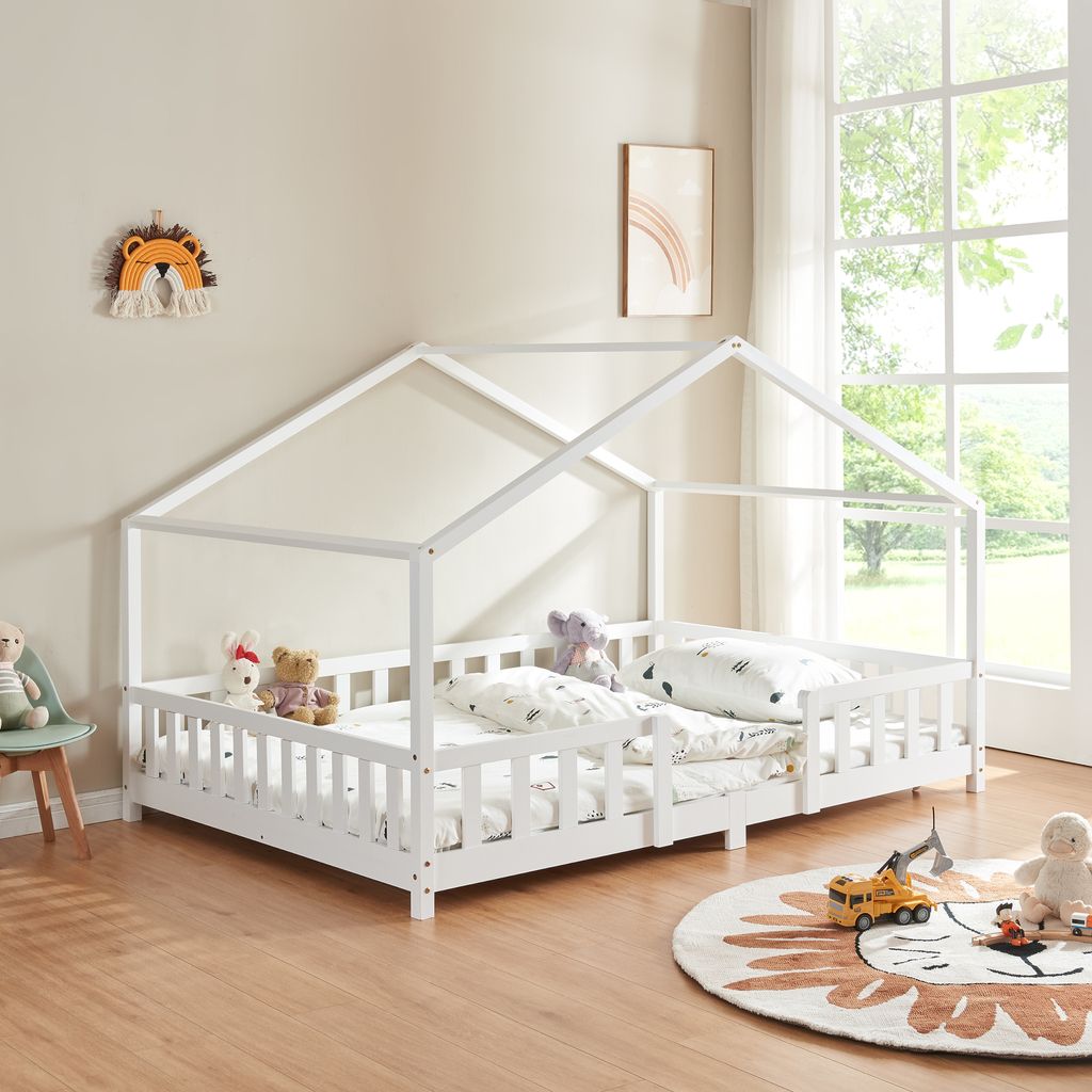 A child's bedroom with a white house-shaped bed.