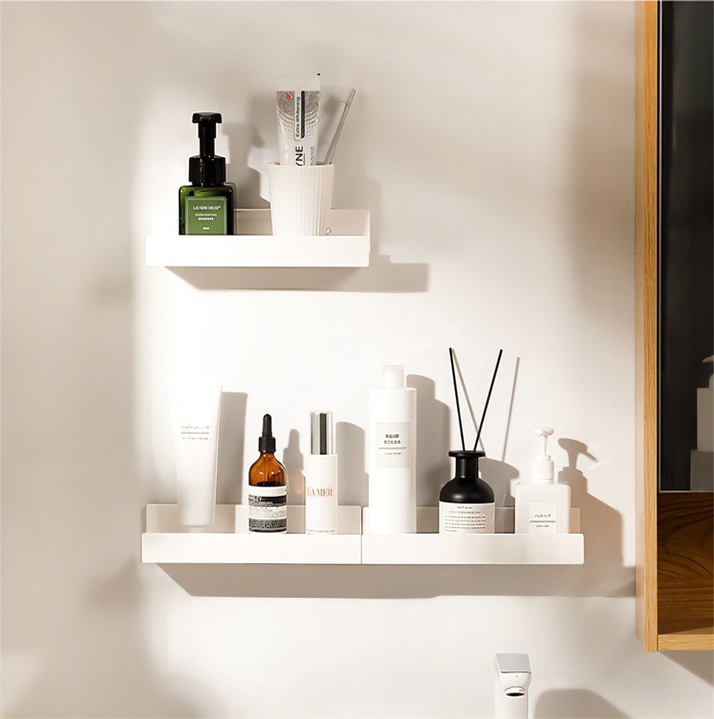 Two white shelves mounted on a white wall, displaying various bathroom or cosmetic products.