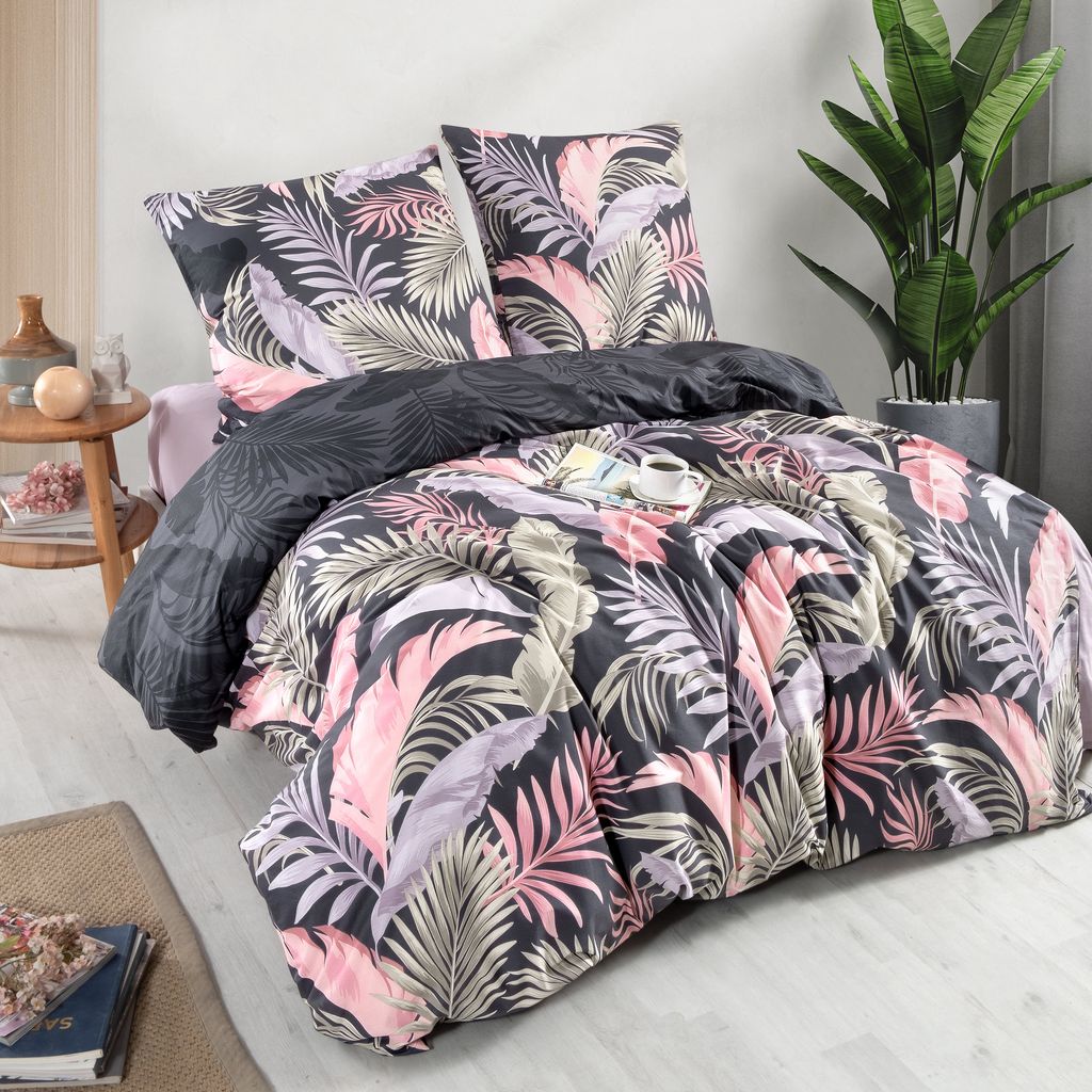 A neatly made bed with a floral duvet cover and pillows, a small side table with decorative items, and a potted plant in the background.