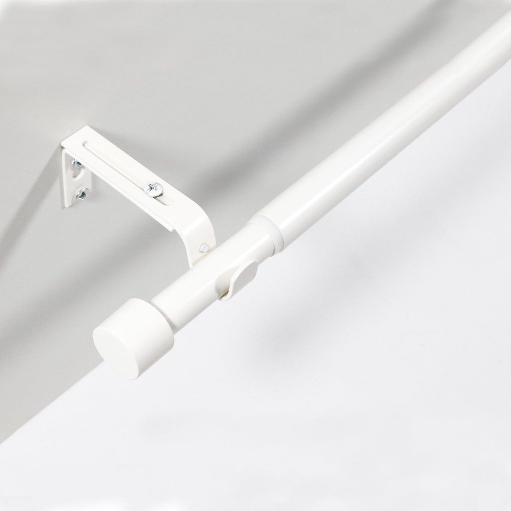 A white adjustable curtain rod mounted on a wall.