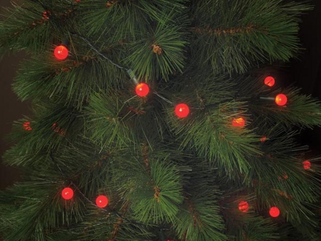 A close-up view of red LED lights on a green Christmas tree.