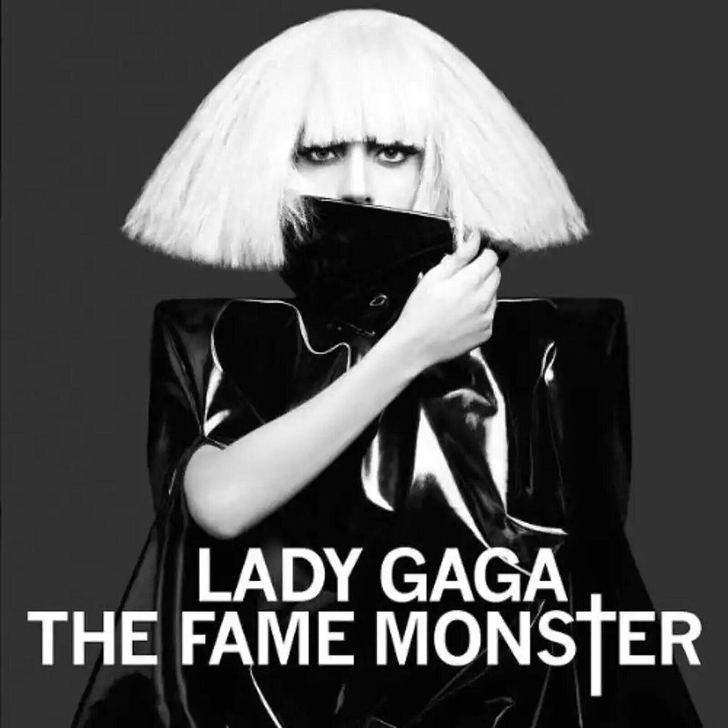 Lady Gaga in a black outfit and white wig, covering her mouth with her hand, with the album title 'The Fame Monster' displayed below.