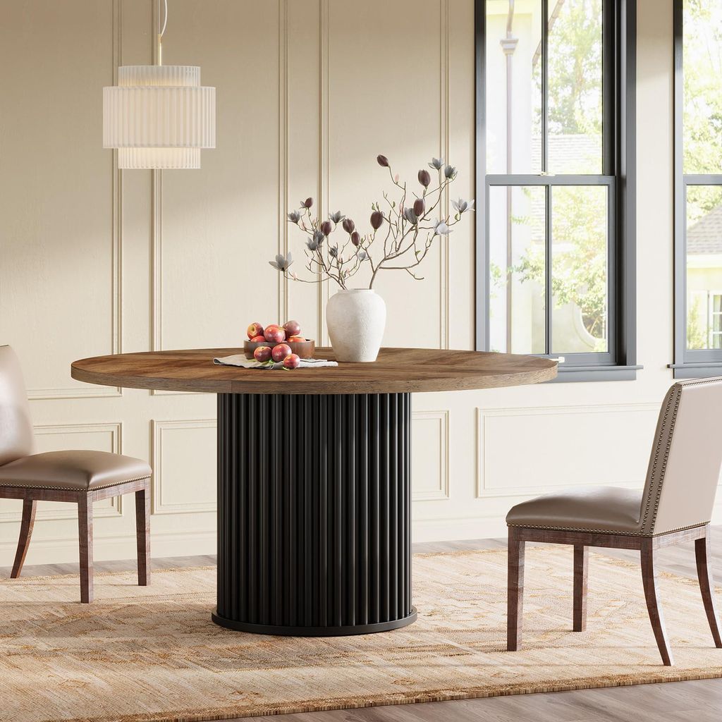 A dining room scene with a round wooden table and chairs.