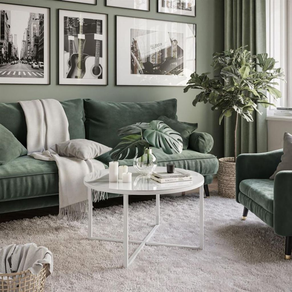 A living room scene with a green sofa, coffee table, and plants.