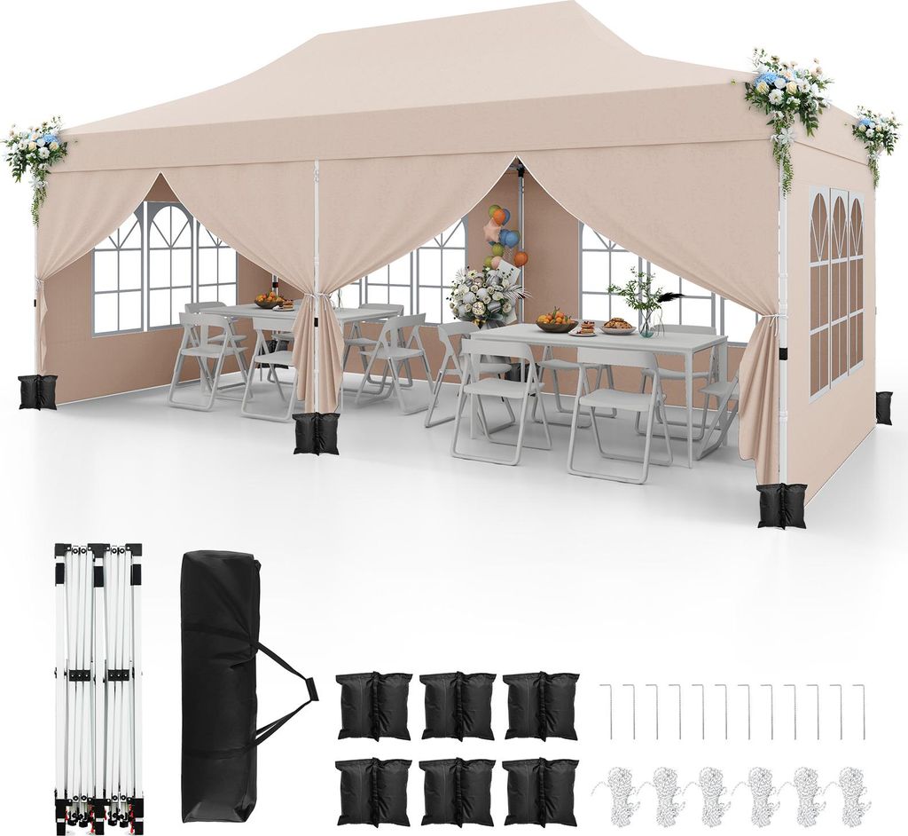 A beige pop-up canopy tent set up with tables and chairs inside, with accessories laid out below.