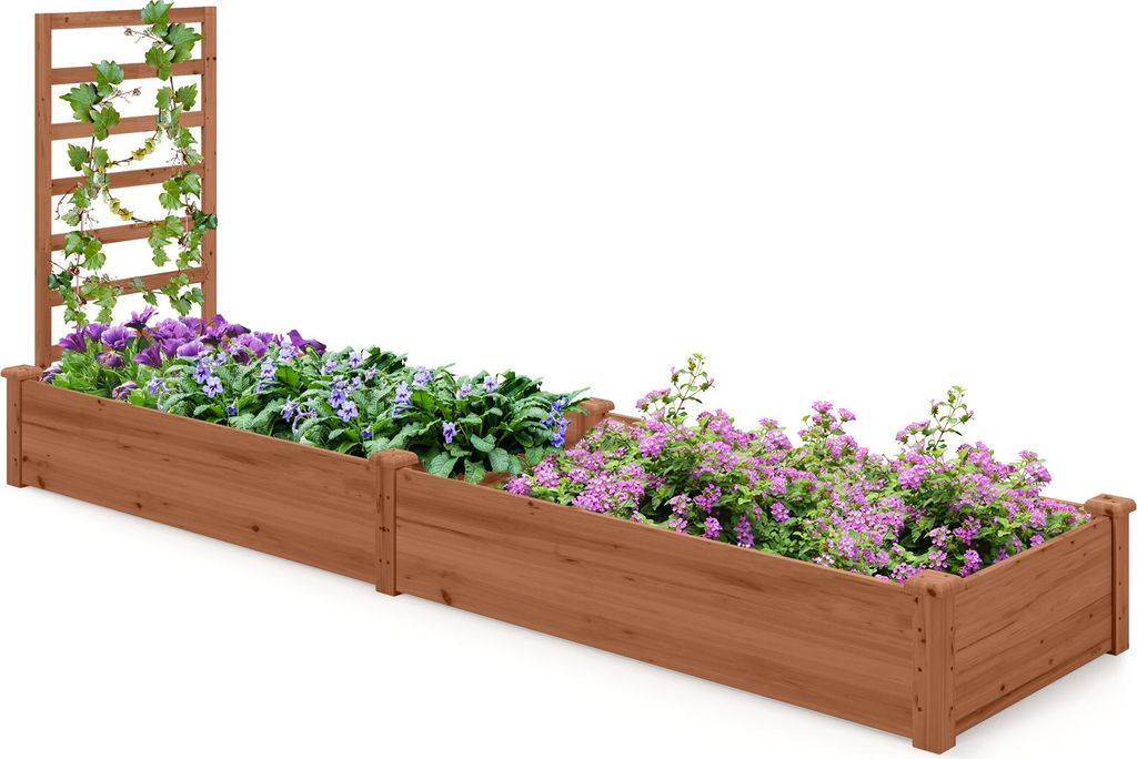 A long, wooden raised garden bed with two sections, filled with purple and pink flowers and a trellis with green vines on one end.