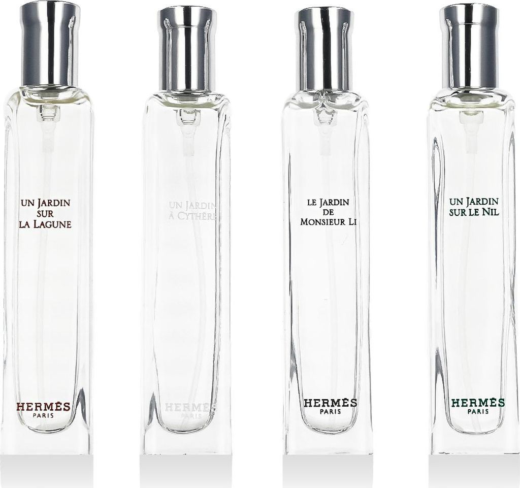 Four clear glass perfume bottles with silver caps, arranged side-by-side against a white background.