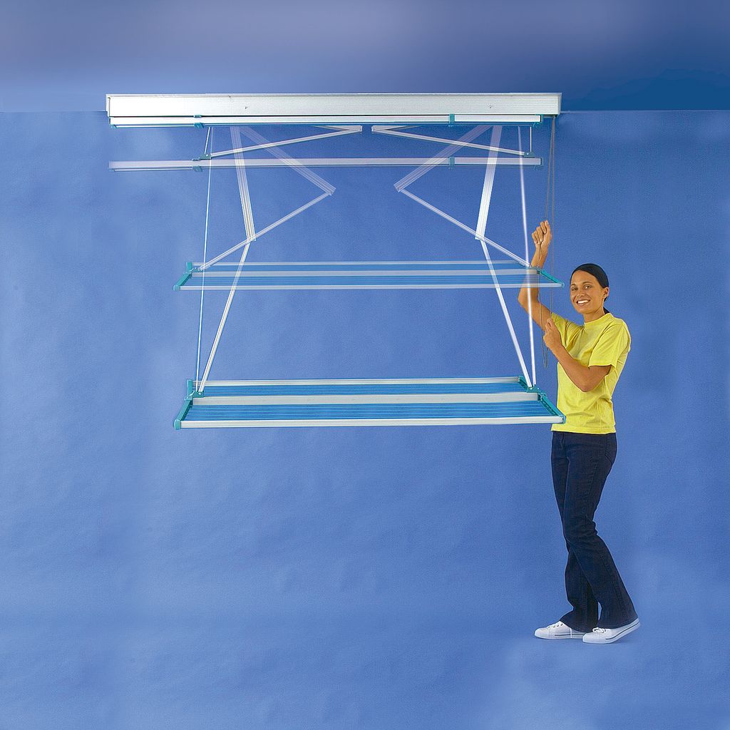 A woman is standing next to a ceiling-mounted clothes drying rack.