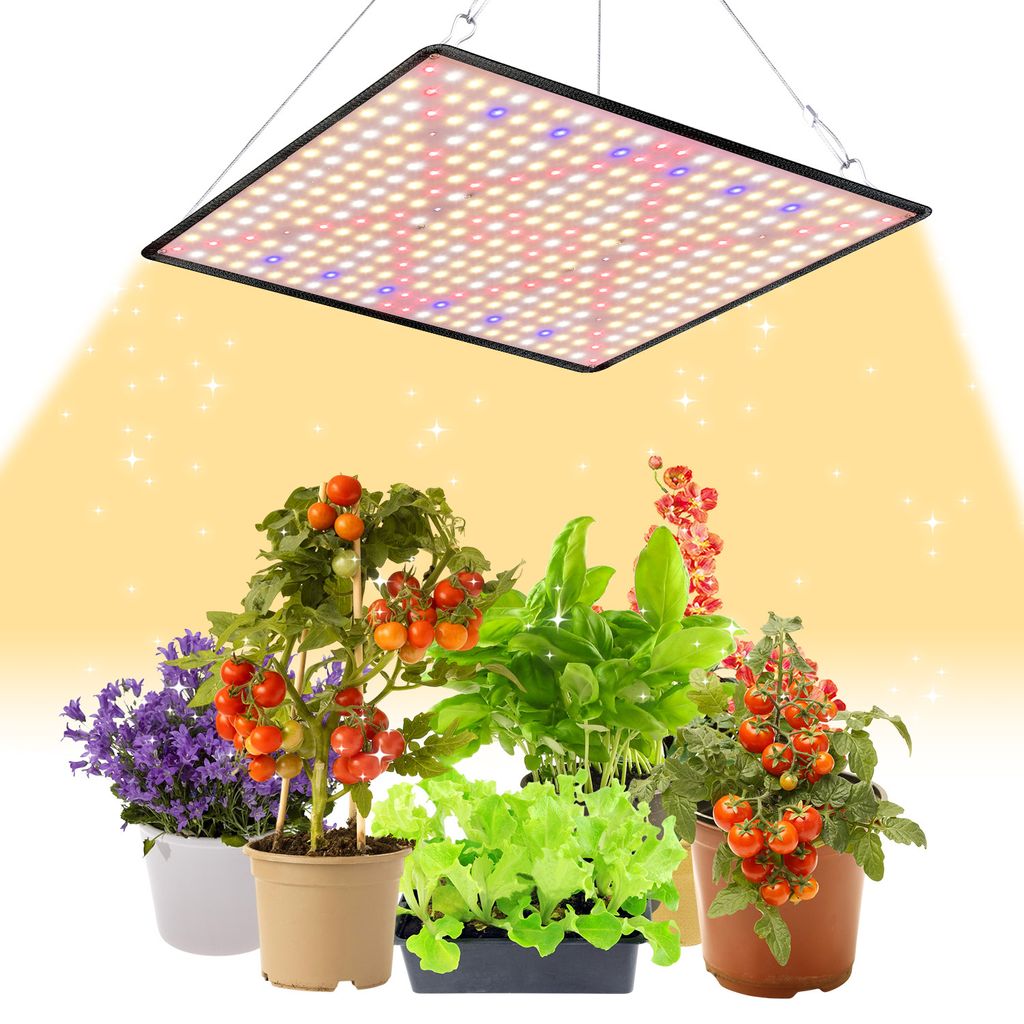 A grow light illuminates several potted plants, including tomatoes, lettuce, basil, and purple flowers.