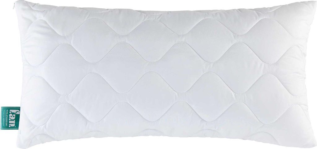 A white quilted pillow with a green tag on the left side.
