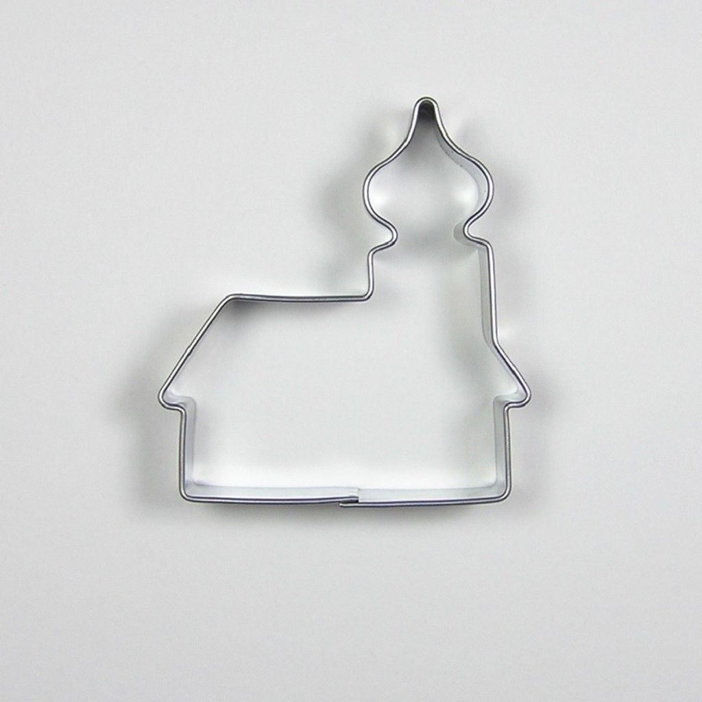 A metal cookie cutter shaped like a church is placed on a white background.