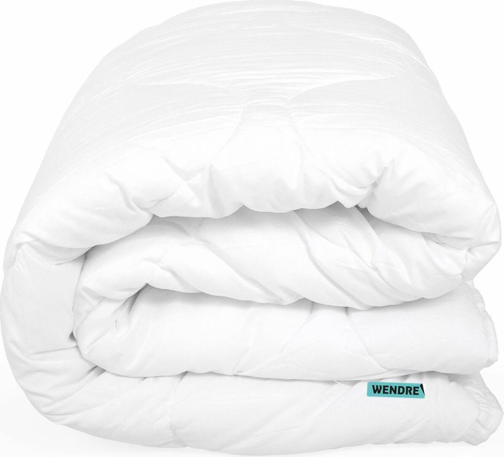 A white duvet folded and lying on a white background.