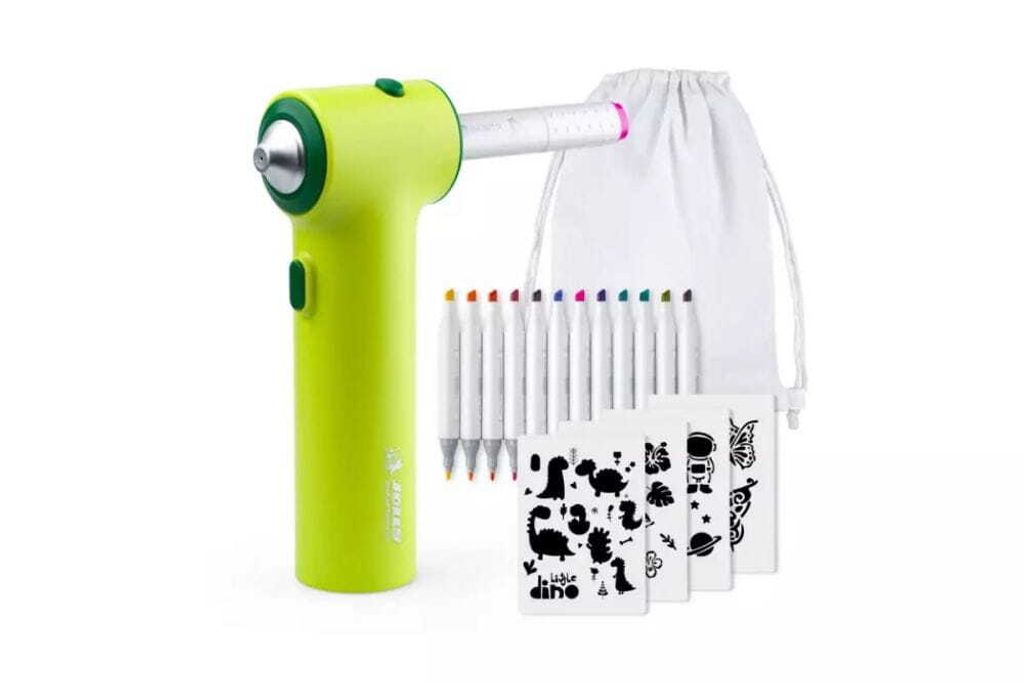 A bright green airbrush set for children, along with markers and stencils, is displayed against a white background.