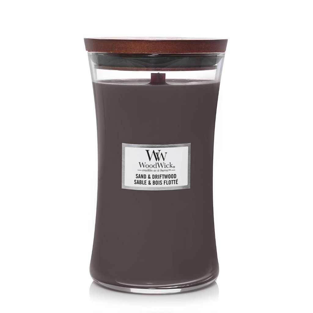A WoodWick Sand & Driftwood scented candle in a glass jar with a wooden lid.