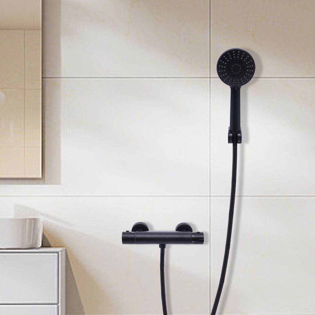 A black shower fixture and handheld showerhead mounted on a tiled wall.