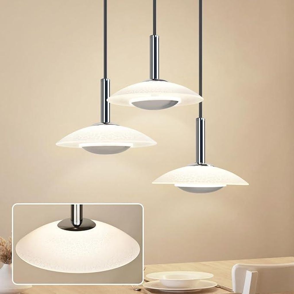Three modern pendant lights hanging over a table.