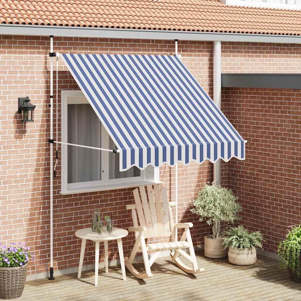 A patio scene with a striped awning extended over a window, a rocking chair, and plants.