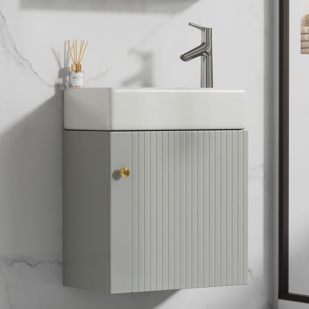 A modern bathroom vanity with a ceramic sink and a single cabinet door.