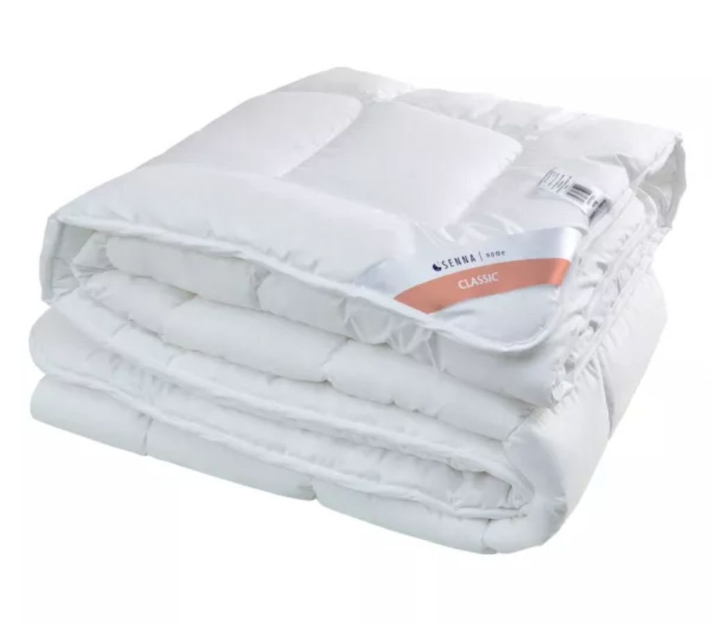 A folded white comforter is shown against a white background.