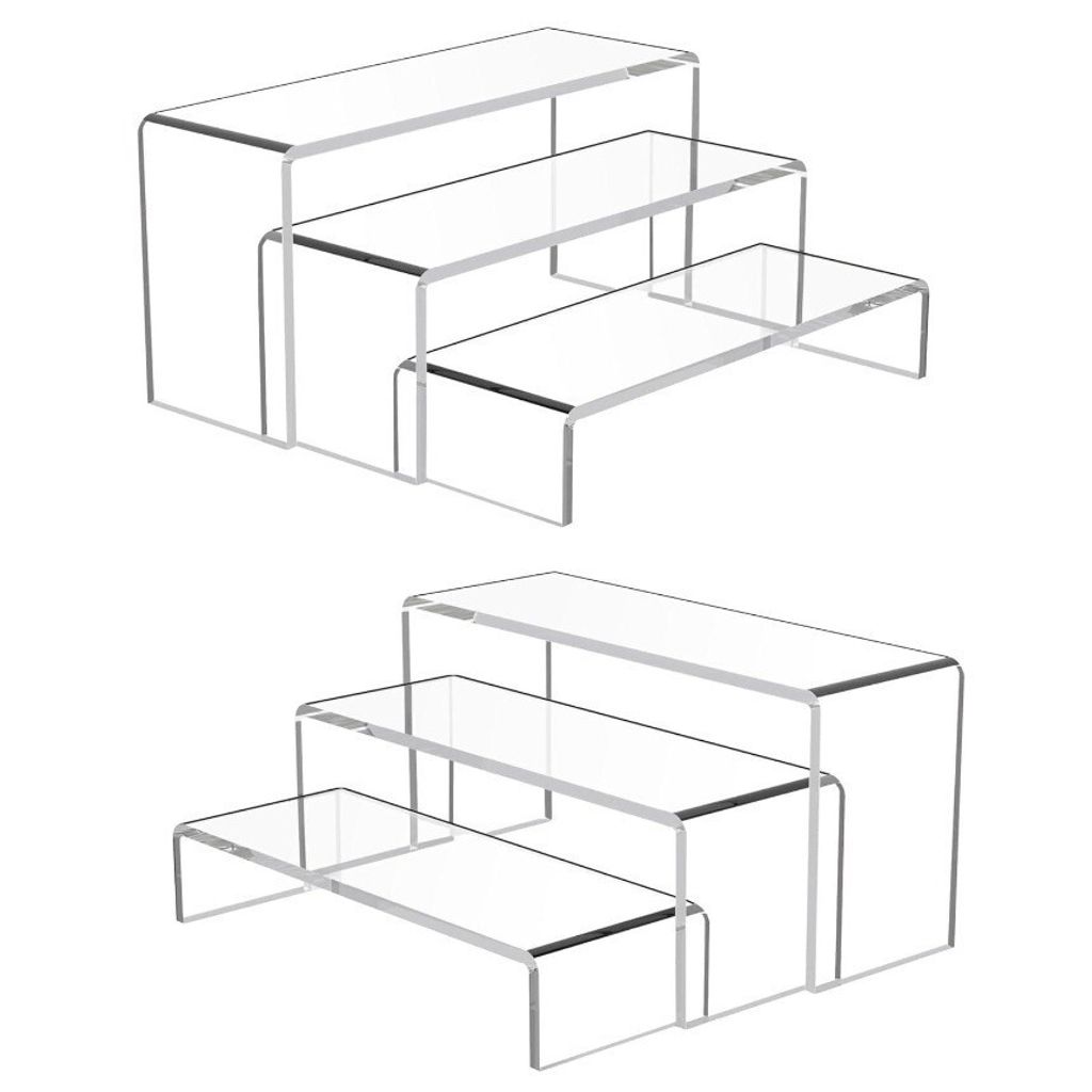 Two sets of clear acrylic display risers are shown against a white background.