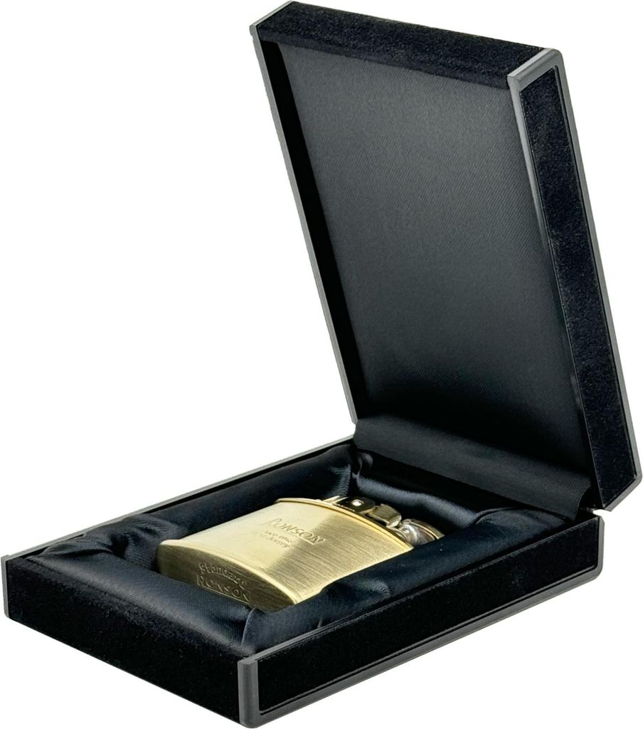 A gold lighter is presented in an open black velvet-lined box.
