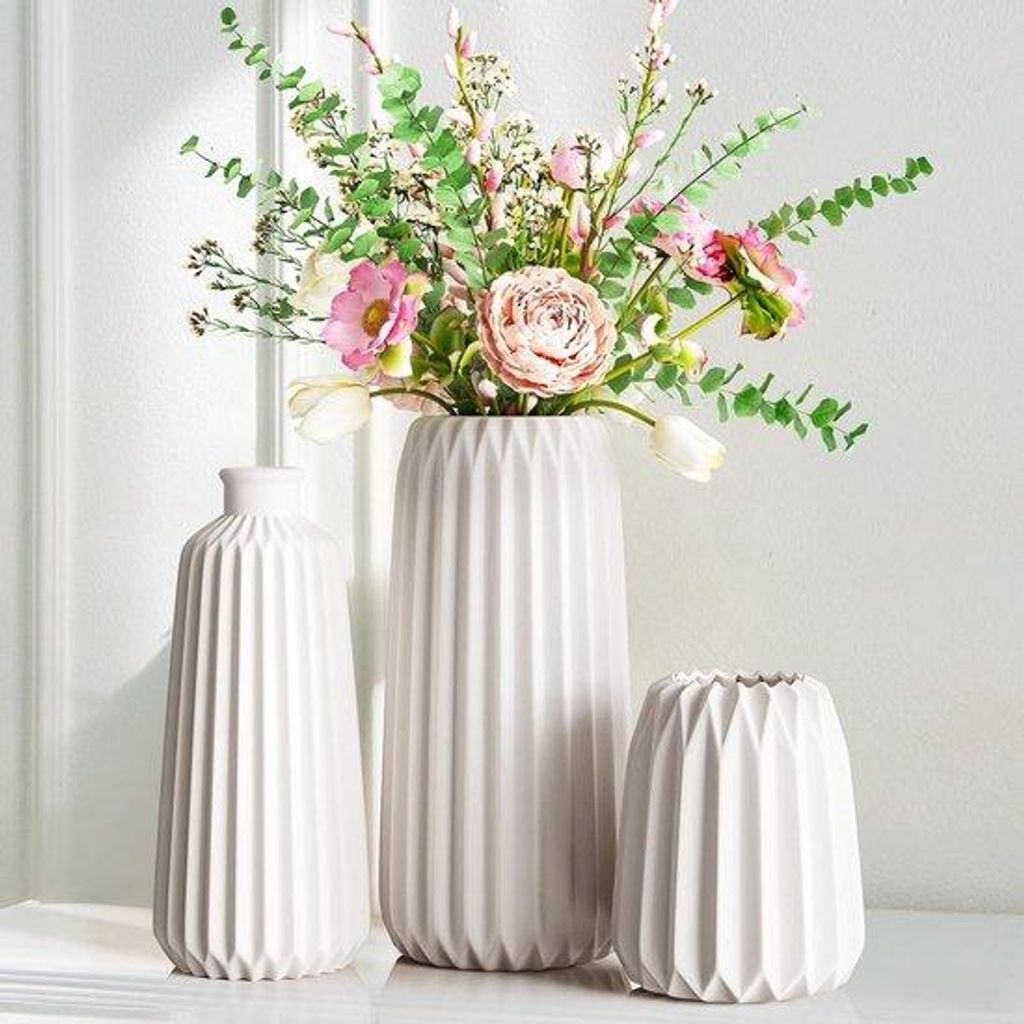 Elegante Vase aus hellem Glas mit glatter Oberfläche für frische Blumen und Dekoration