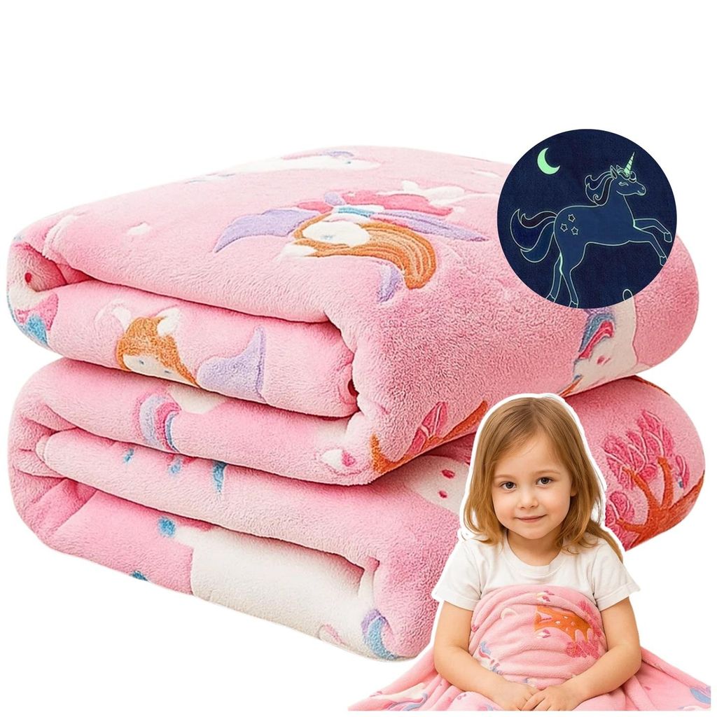 A folded pink blanket with unicorn and princess motifs, a glowing unicorn graphic, and a young girl holding a smaller blanket.