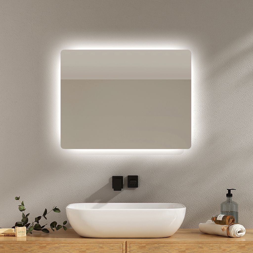 A modern bathroom vanity with a lit mirror, sink, and wooden countertop.