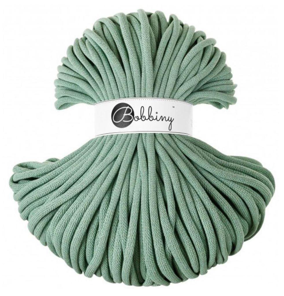 A ball of green yarn with a white label around the middle.