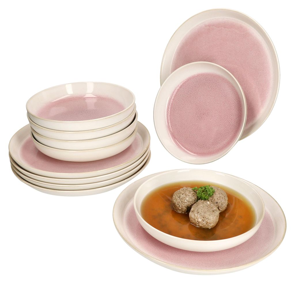 A set of pink and white ceramic tableware, including plates and bowls, with a bowl of soup and meatballs in the foreground.