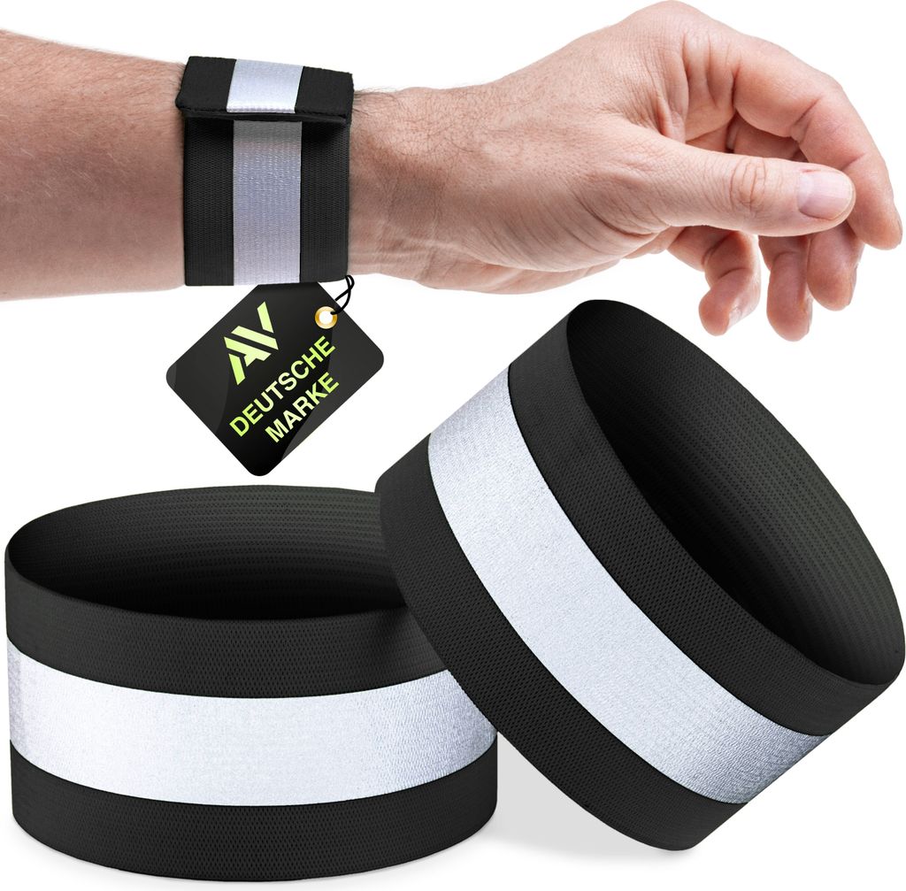 A person's wrist wearing a black reflective band, with two more bands in the foreground.