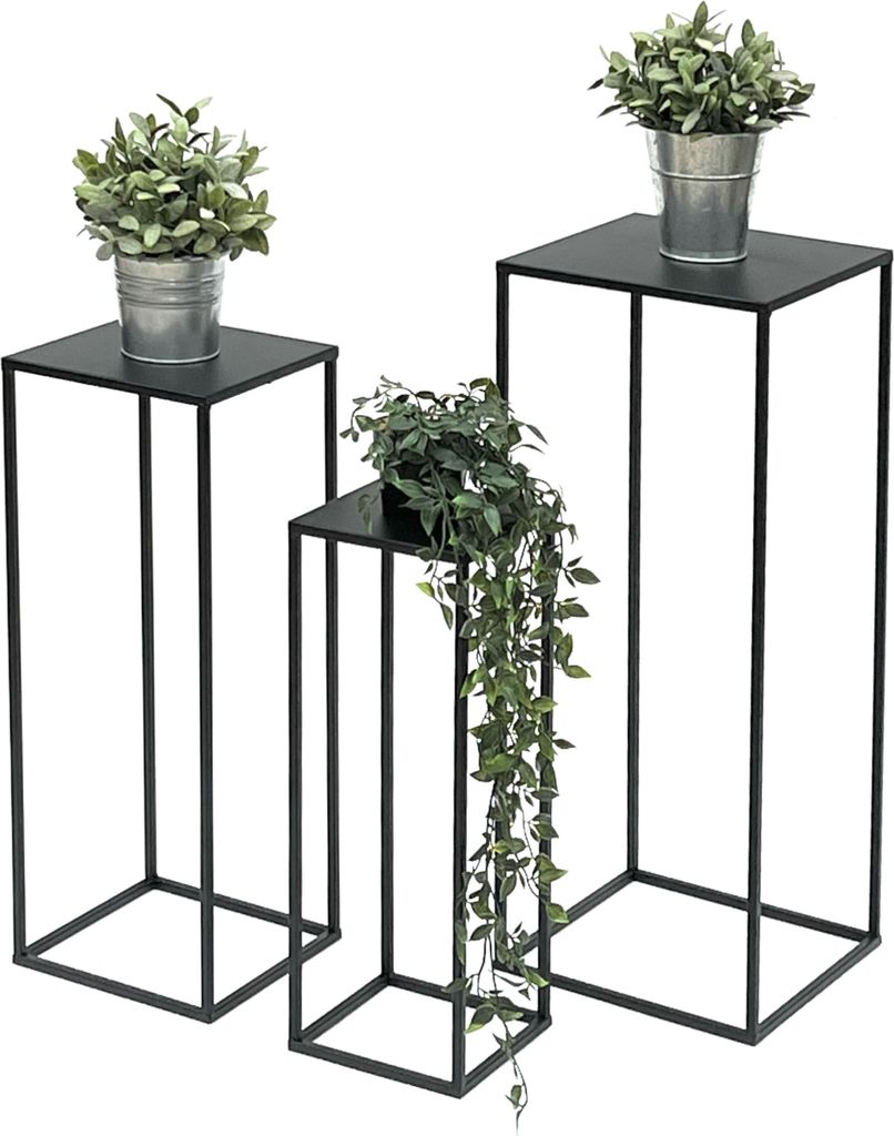 Three black metal plant stands of varying heights, each holding a potted plant.