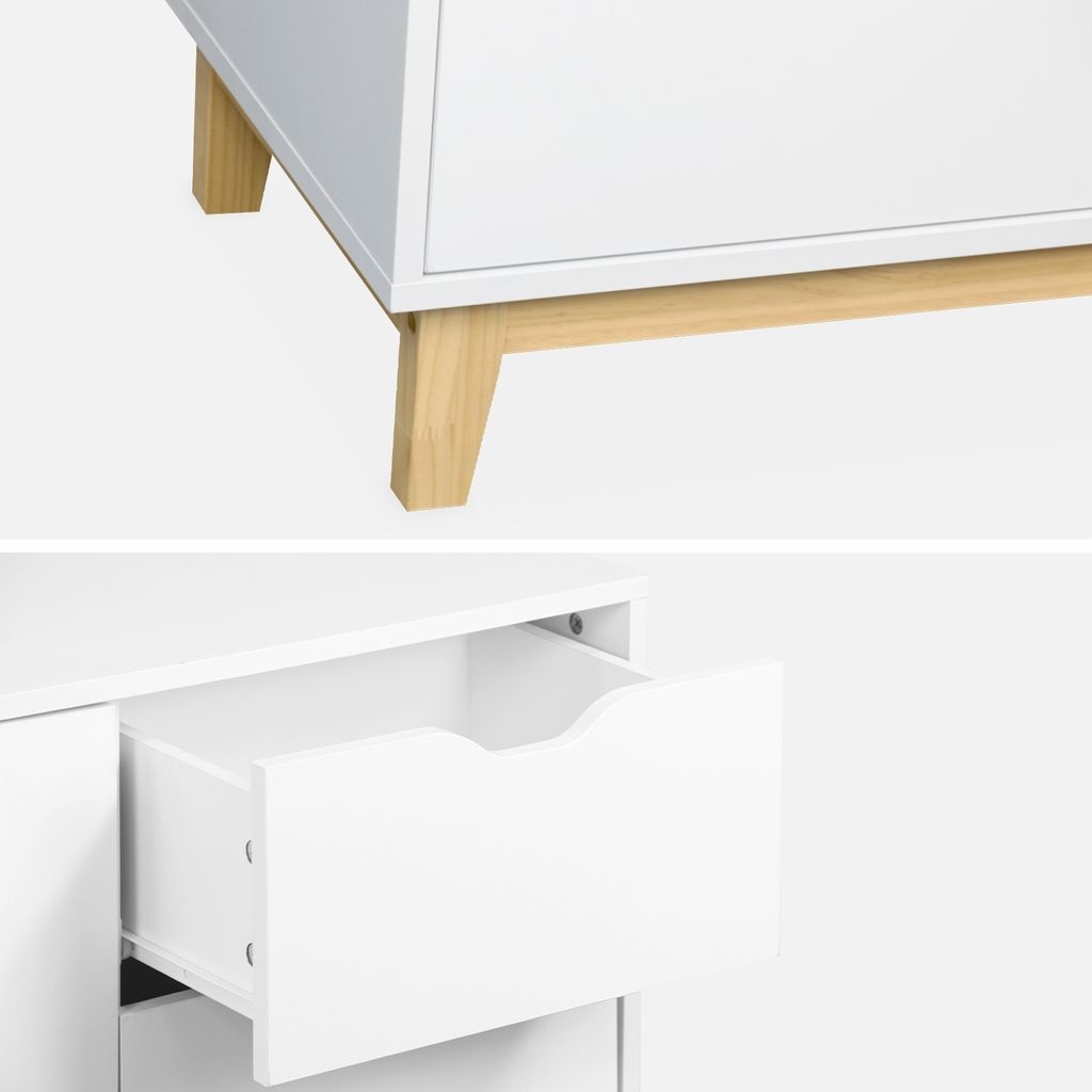 A close-up view of a white dresser with wooden legs and an open drawer.