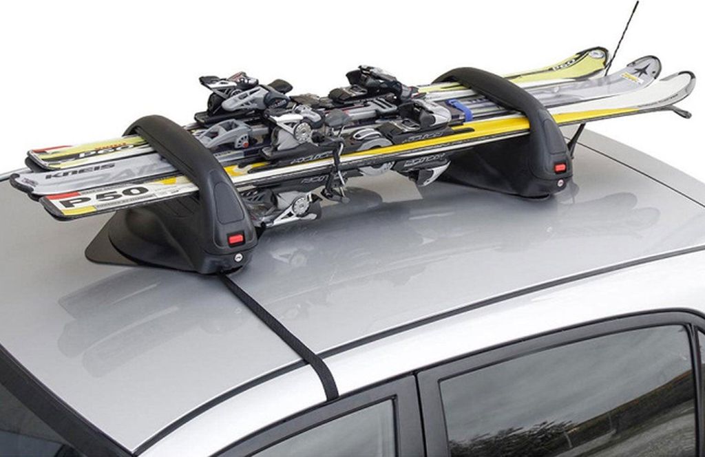 A ski and snowboard carrier mounted on the roof of a silver car.