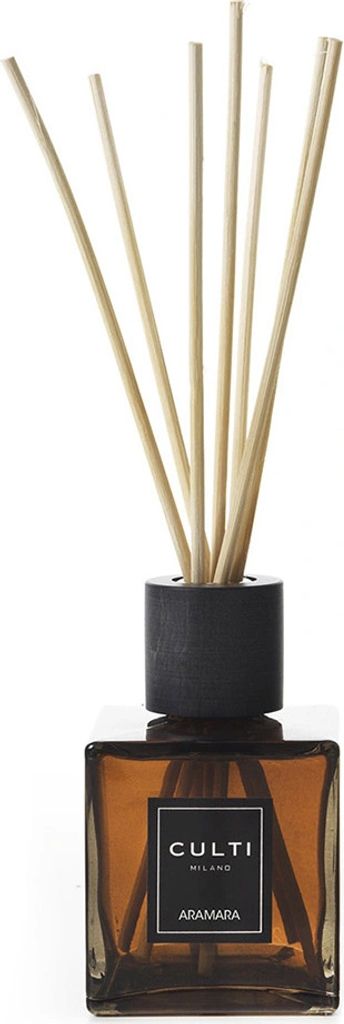 A diffuser with reeds in a brown glass bottle.