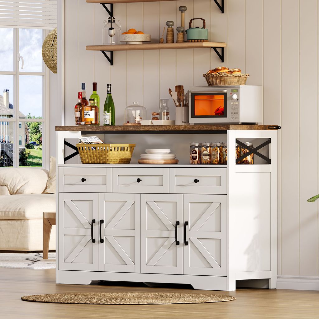 A white buffet sideboard with a wooden top, set against a white paneled wall, with shelves above displaying kitchen items and a window to the left showing a garden view.