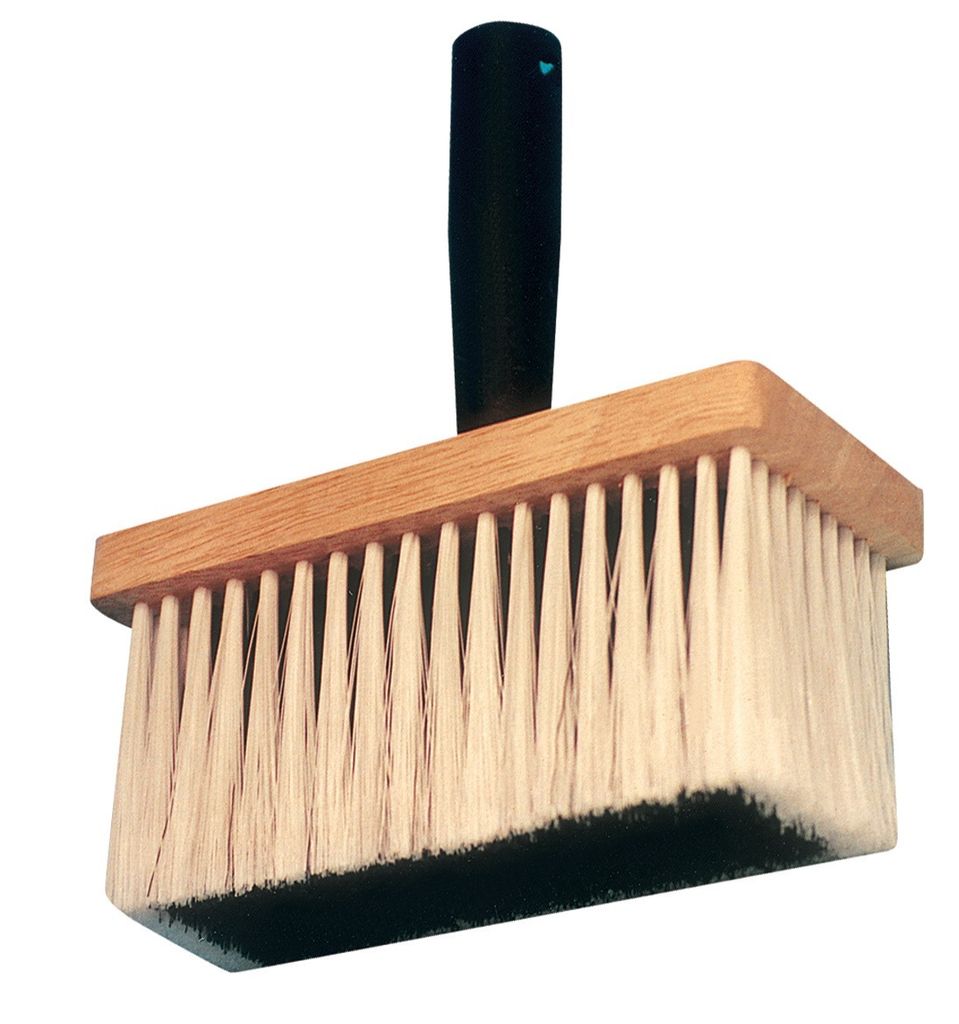 A rectangular brush with white bristles and a wooden frame, attached to a black handle.